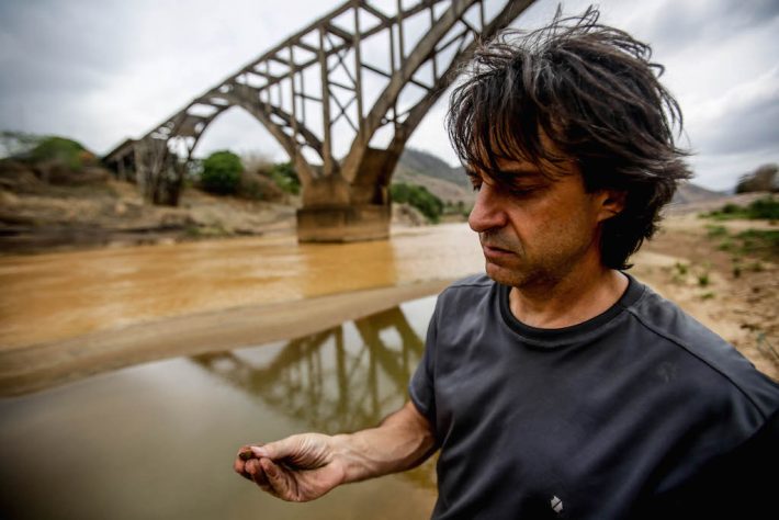 O biólogo Dante Pavan examina moluscos e crustáceos à beira do Rio Doce em Itapina. Foto: Gabriela Biló/Estadão